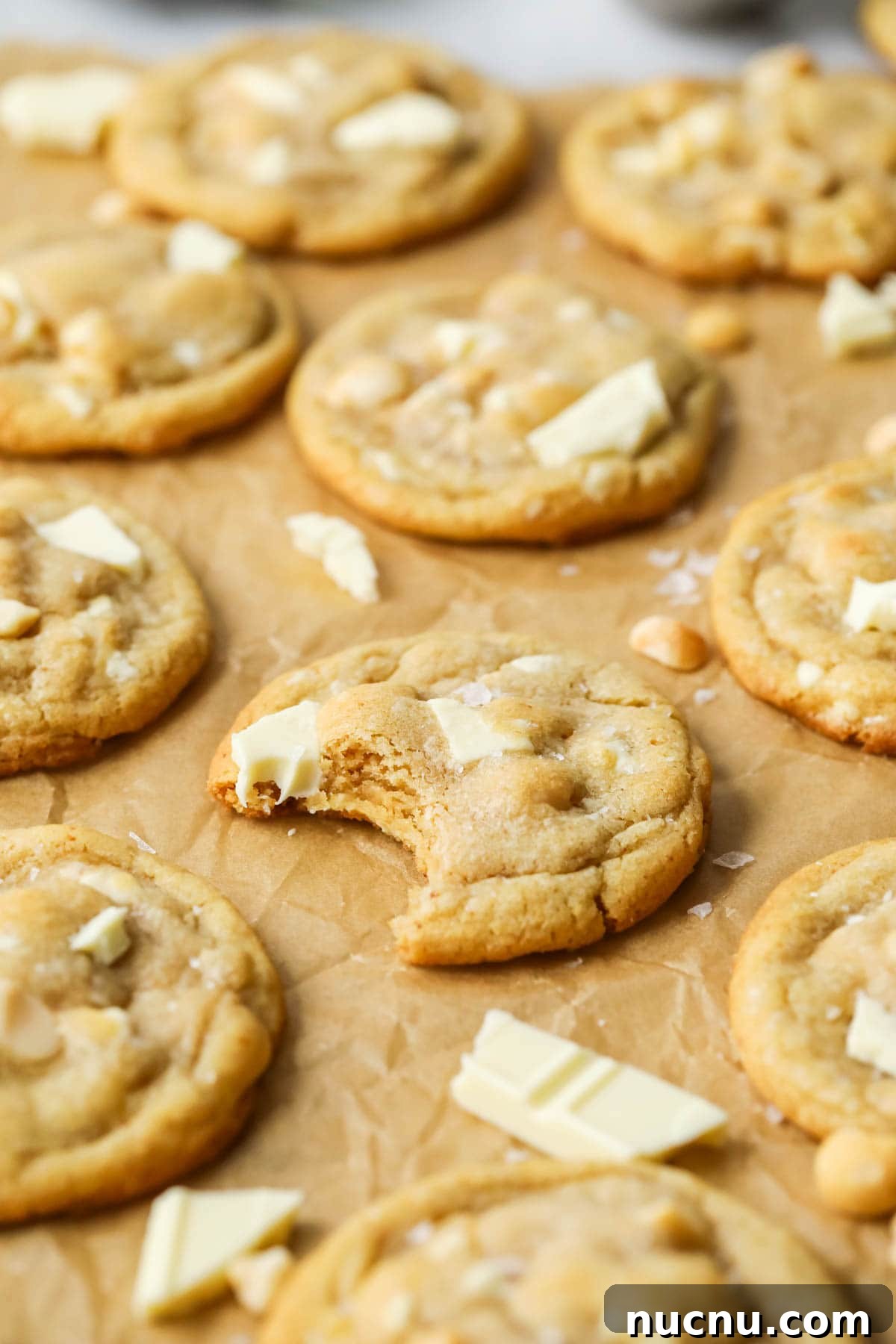 White Chocolate Macadamia Nut Cookies Recipe for Chewy, Crisp Bites 6 Close-up view of a white chocolate macadamia nut cookie missing a bite.