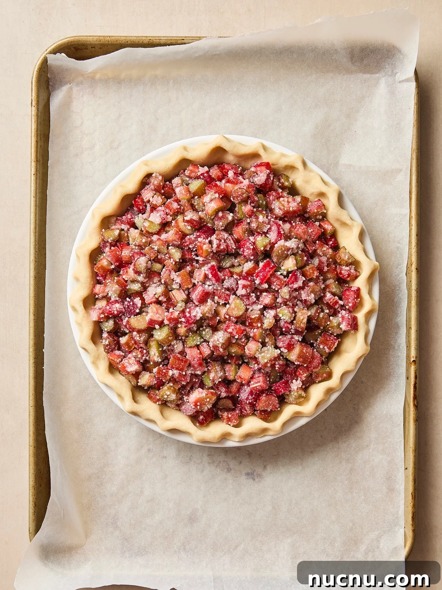 Rhubarb pie on a baking sheet before being baked.