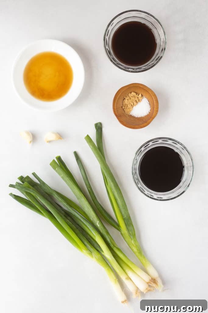 Gluten-Free Teriyaki Marinade Recipe for Stir-Fries & Grilling 4 Top down shot of ingredients for a teriyaki marinade in clear and white bowls, as well as two cloves of garlic and five fresh green onions.