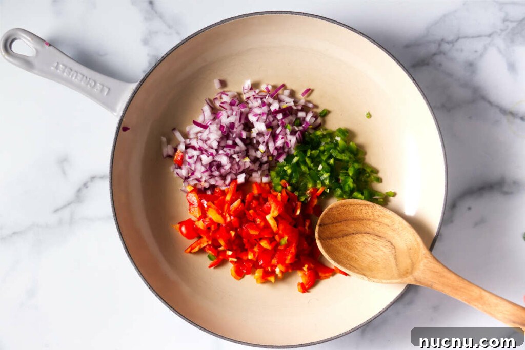 Baja-Style Fish Taco Bowls with Cilantro Lime Slaw 5 Adding onions red bell peppers and green bell peppers to a skillet.