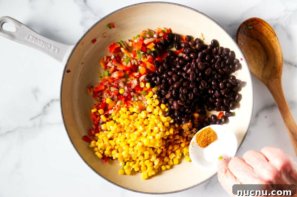 Baja-Style Fish Taco Bowls with Cilantro Lime Slaw 6 Placing corn, black beans and spices in the skillet with the sauteed veggies.