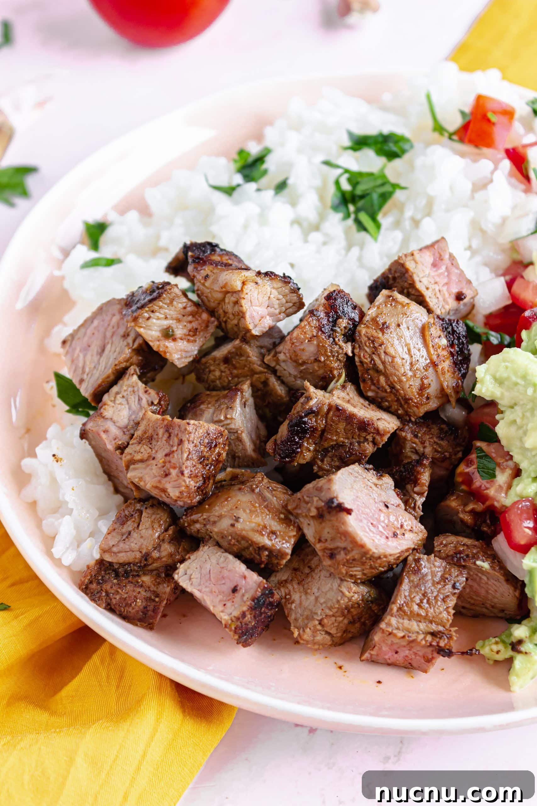 homemade chipotle steak strips next to white rice in a white bowl