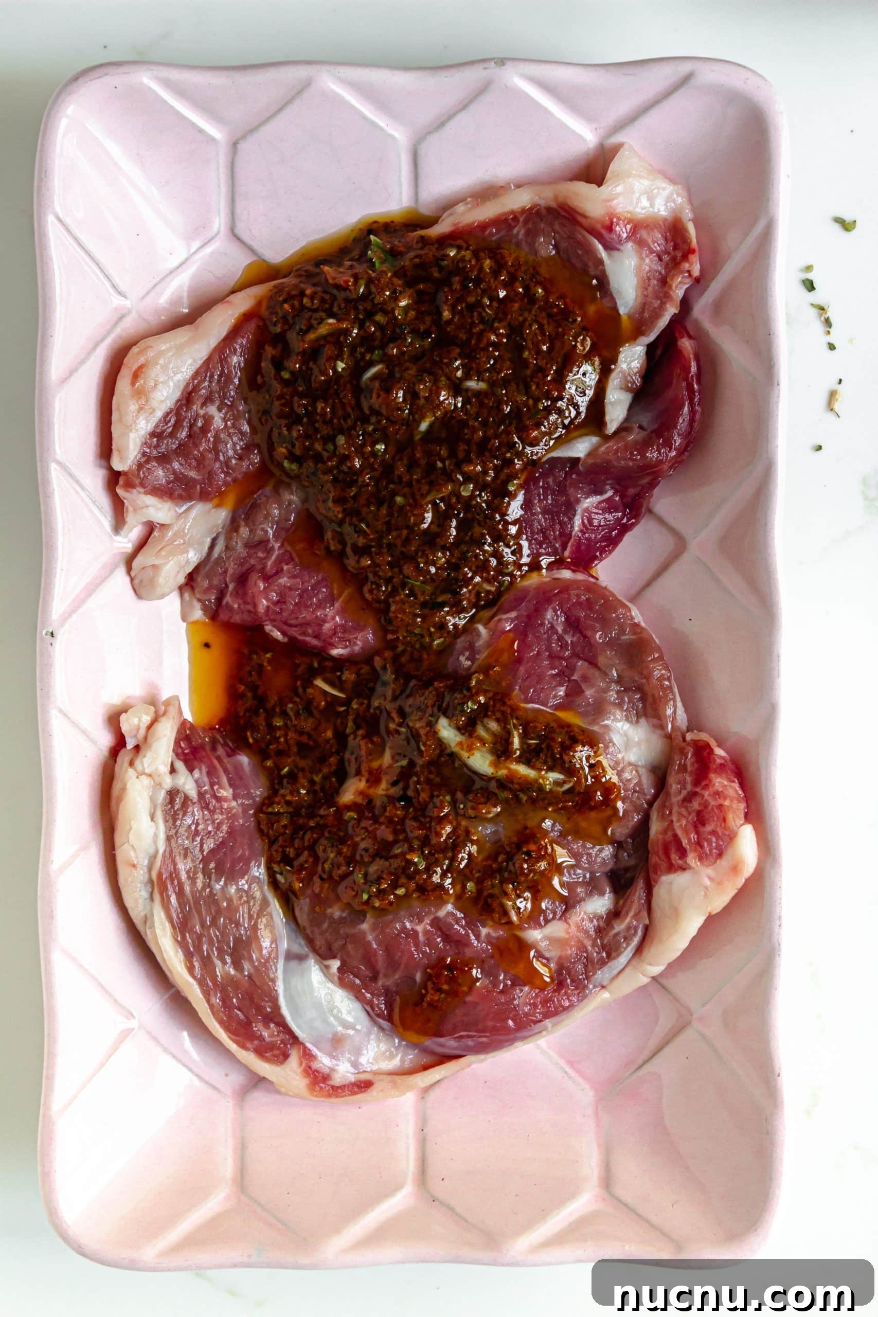 adobo marinade poured over two raw steaks