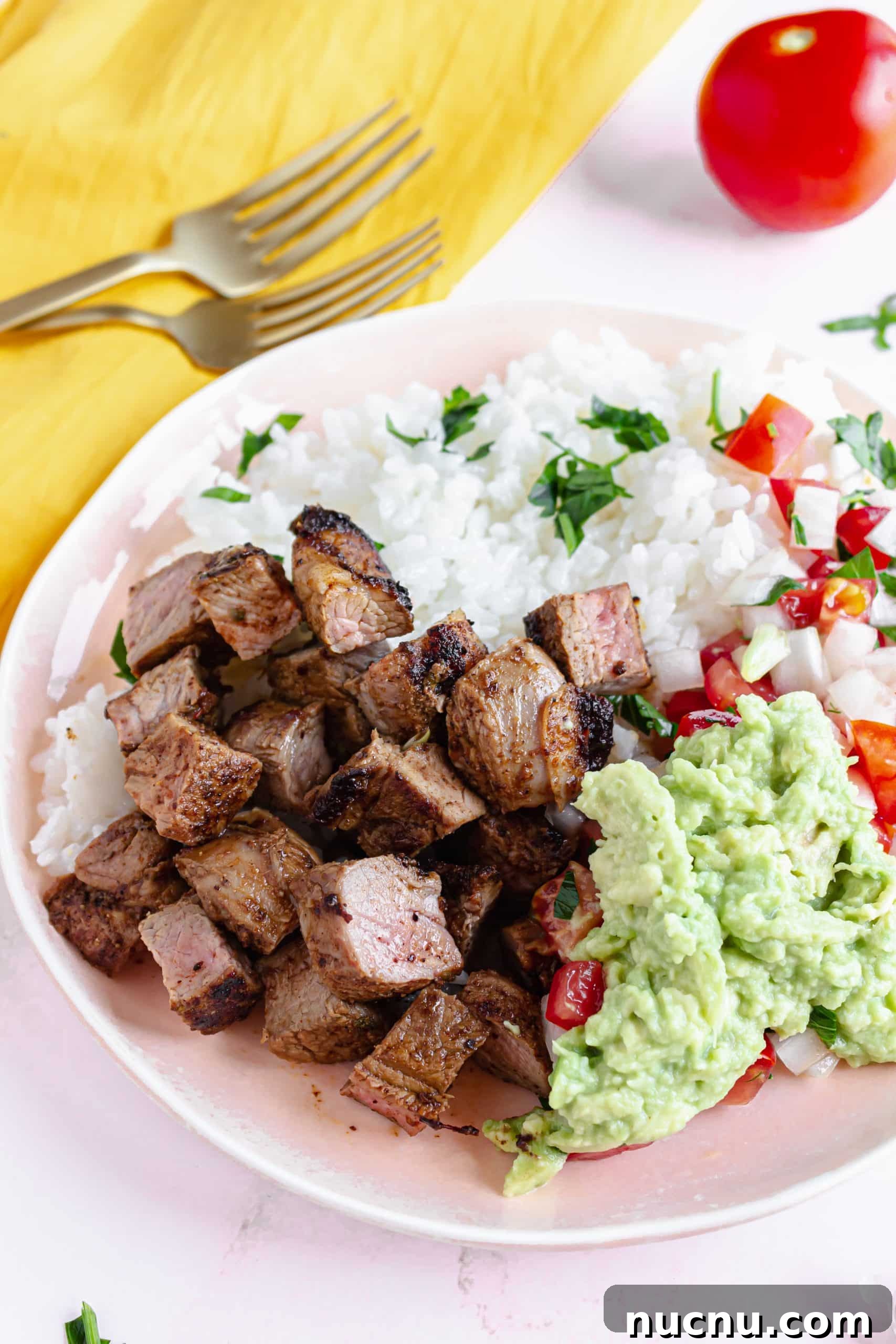 homemade chipotle steak strips next to white rice in a white bowl