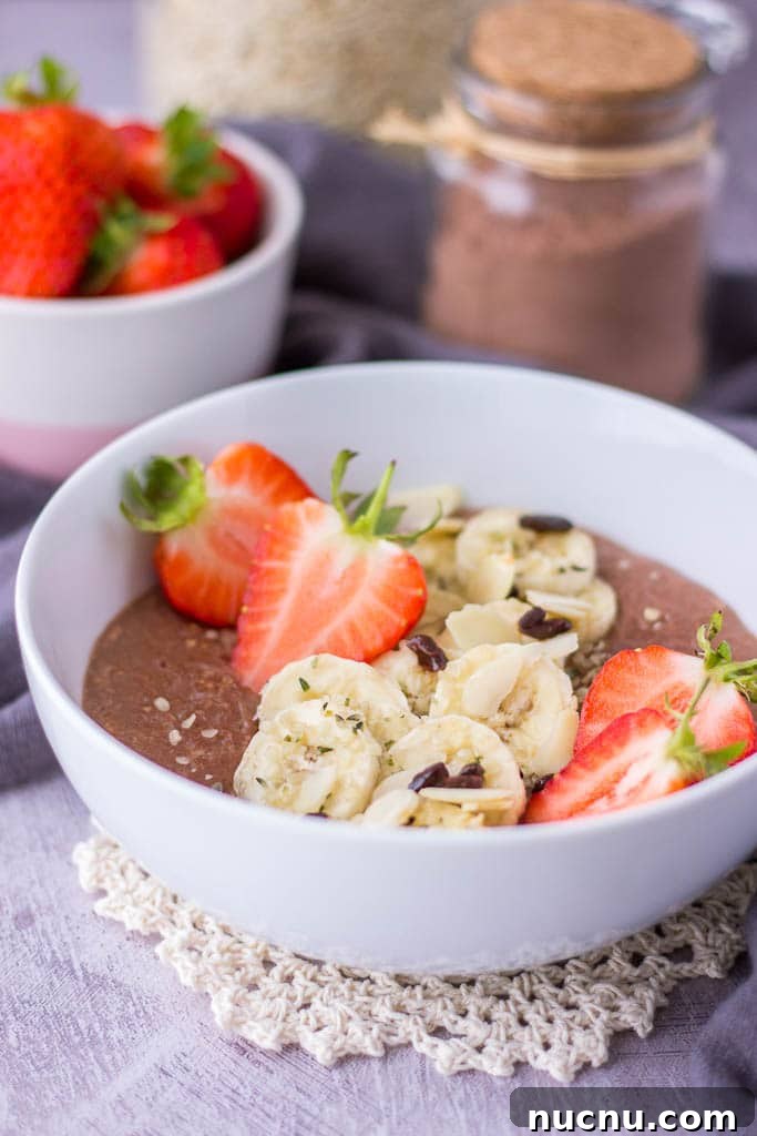 Healthy chocolate oatmeal porridge topped with banana and fresh strawberries