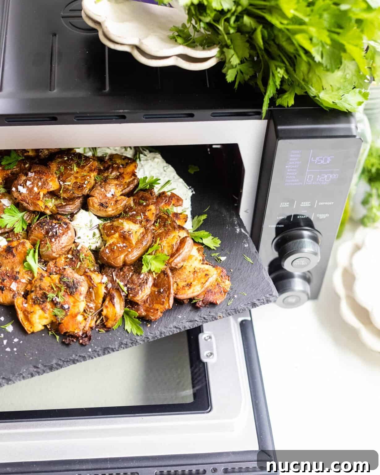 Crispy Smashed Potatoes with Whipped Herb Ricotta Dip 6 a tray of potatoes being pulled out of a toaster oven
