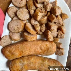 What to Serve with Lasagna: Appetizers, Sides & Desserts 11 A white plate with cooked air fryer Italian sausage on it. Some whole and some cut.