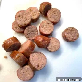 What to Serve with Lasagna: Appetizers, Sides & Desserts 12 Oven-cooked, sliced Italian sausage on a white cutting board.
