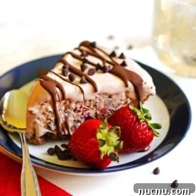 What to Serve with Lasagna: Appetizers, Sides & Desserts 14 A slice of ice cream pie on a plate with a spoon and two strawberries next to the pie