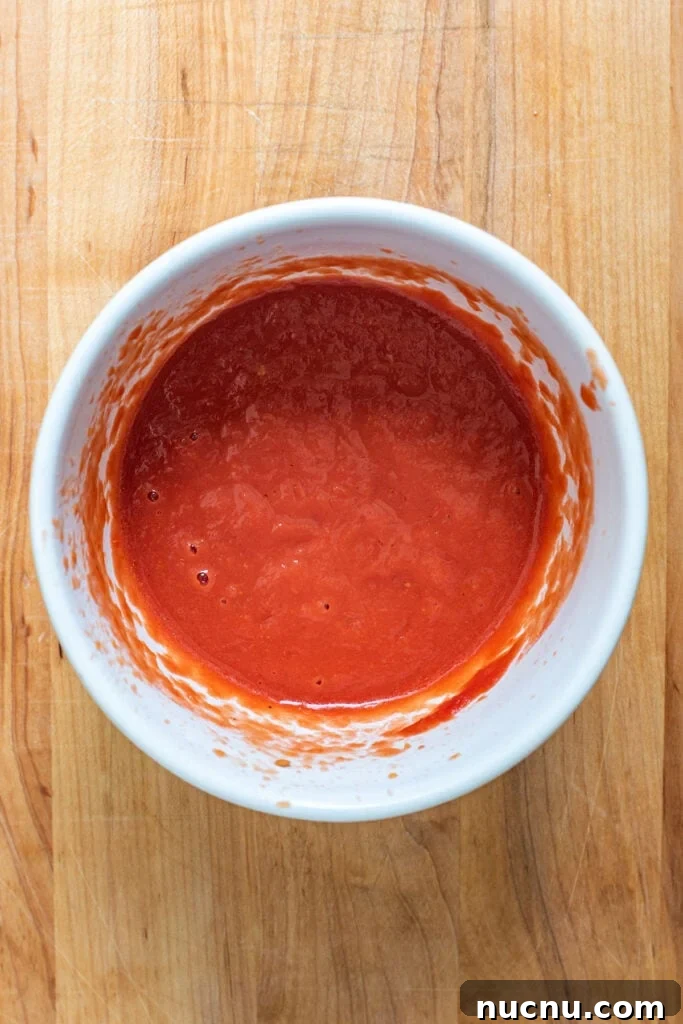Blended San Marzano tomatoes in small white bowl.