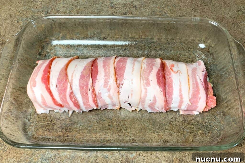 Raw bacon wrapped around pork and sauerkraut roll-up