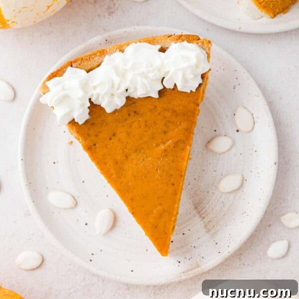 Slice of pumpkin pie, viewed from above, with whipped cream.