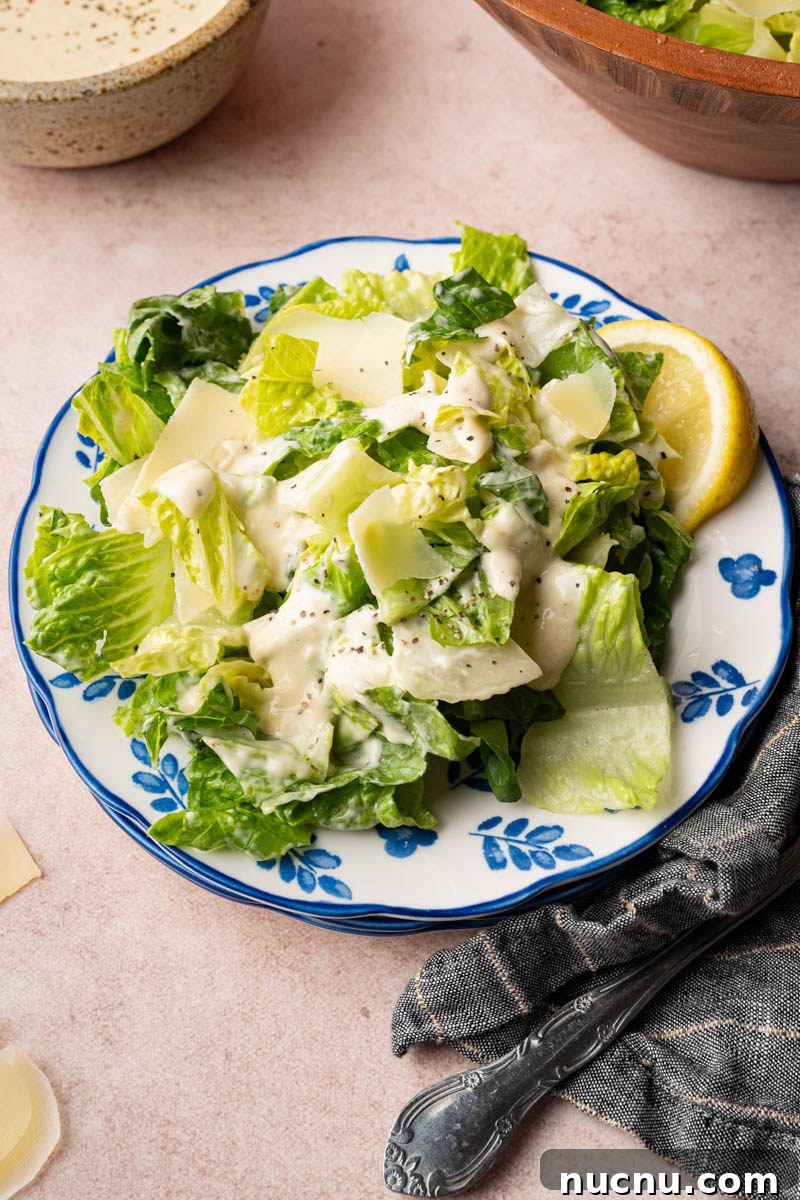 Classic Caesar Salad with Creamy Homemade Dressing and Croutons 6 Caesar salad on a plate with a lemon wedge for serving.