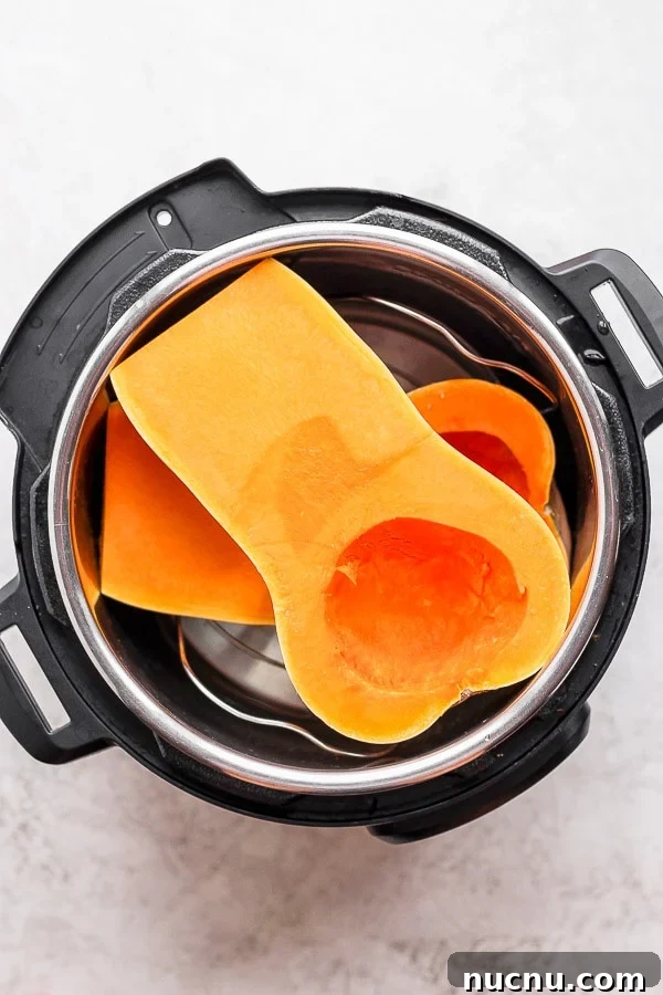 Two butternut squash halves placed in the Instant Pot.