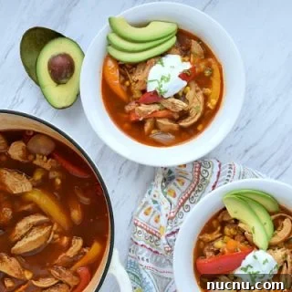 two bowls and a pot of chicken fajita soup on a table