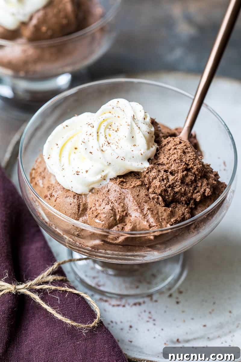 Decadent Homemade Chocolate Mousse Recipe for Silky Results 2 bowl of chocolate mousse with spoon and whipped cream in front of another dish and next to a napkin.