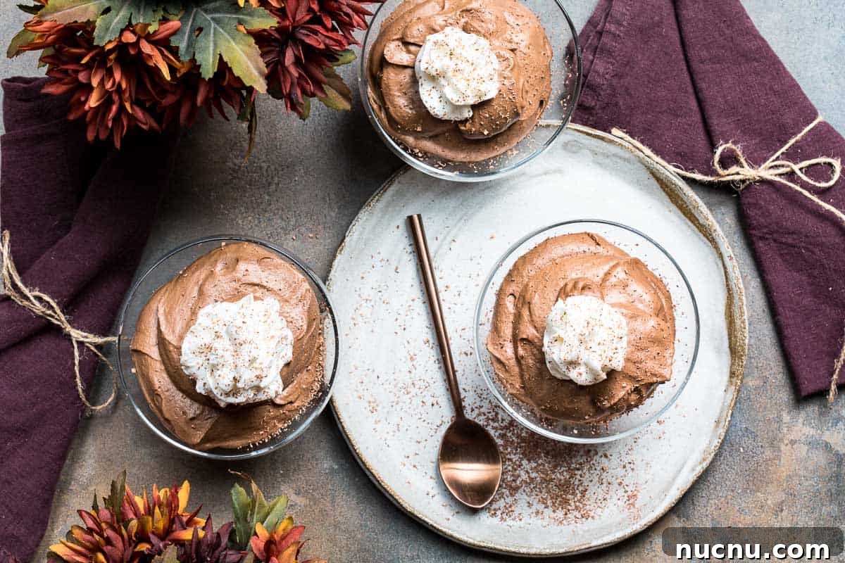 Decadent Homemade Chocolate Mousse Recipe for Silky Results 11 three dishes of chocolate mousse with spoon, napkins, and some flowers.