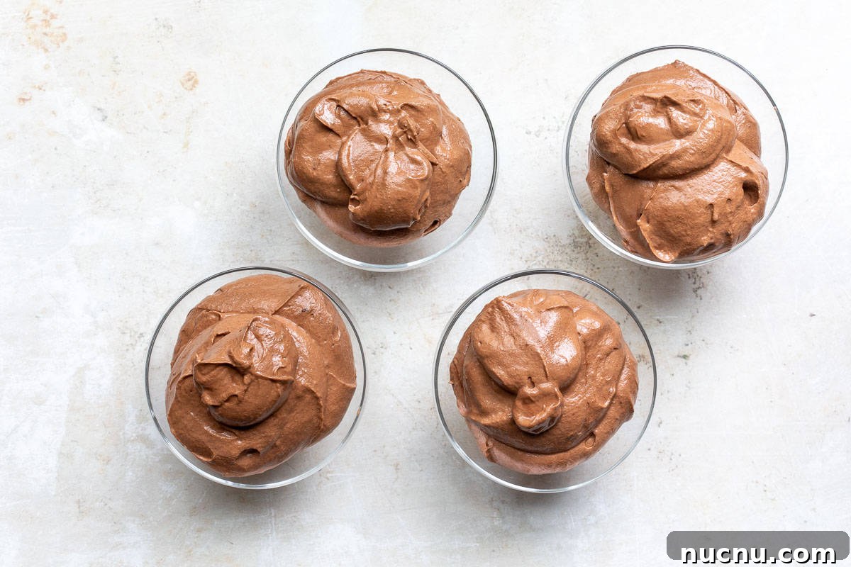 Decadent Homemade Chocolate Mousse Recipe for Silky Results 10 four glass bowls filled with chocolate mousse.