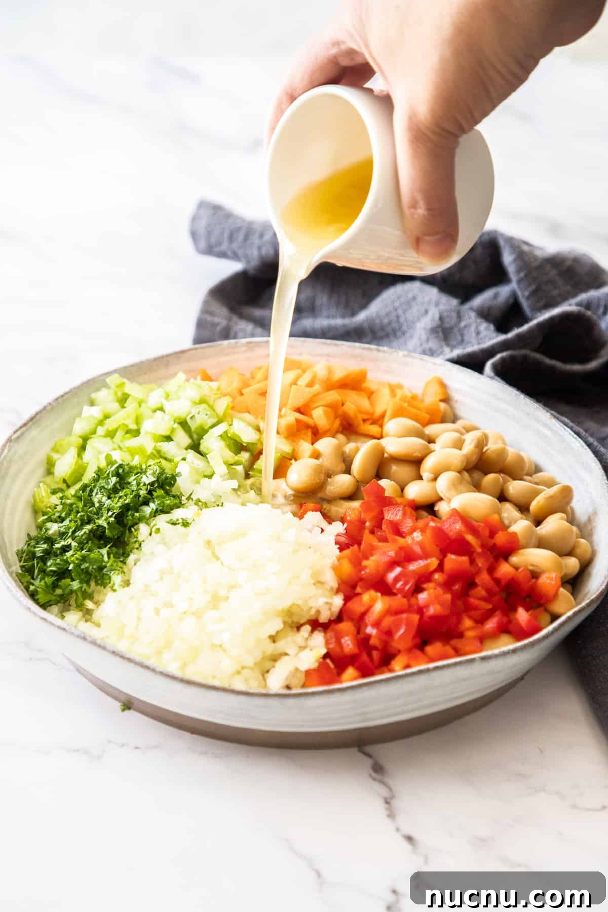 Creamy Butter Bean Salad with Lemon & Herbs — Quick Summer Side 5 Step 2 of preparing this recipe - pouring the dressing over the salad.