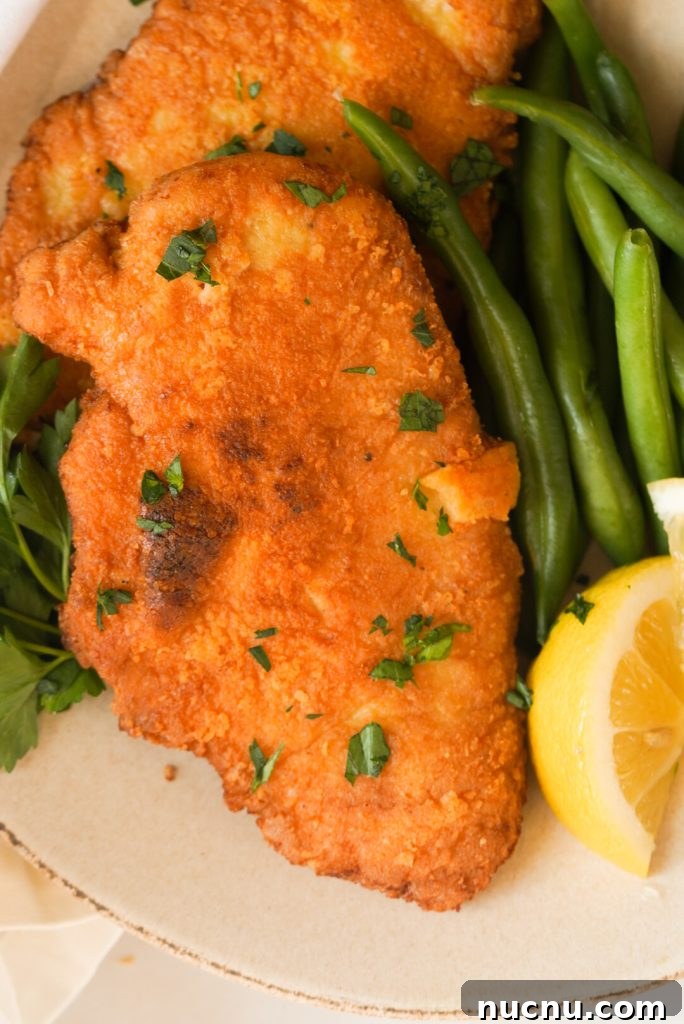 crusted Romano chicken breast with green beans and lemon