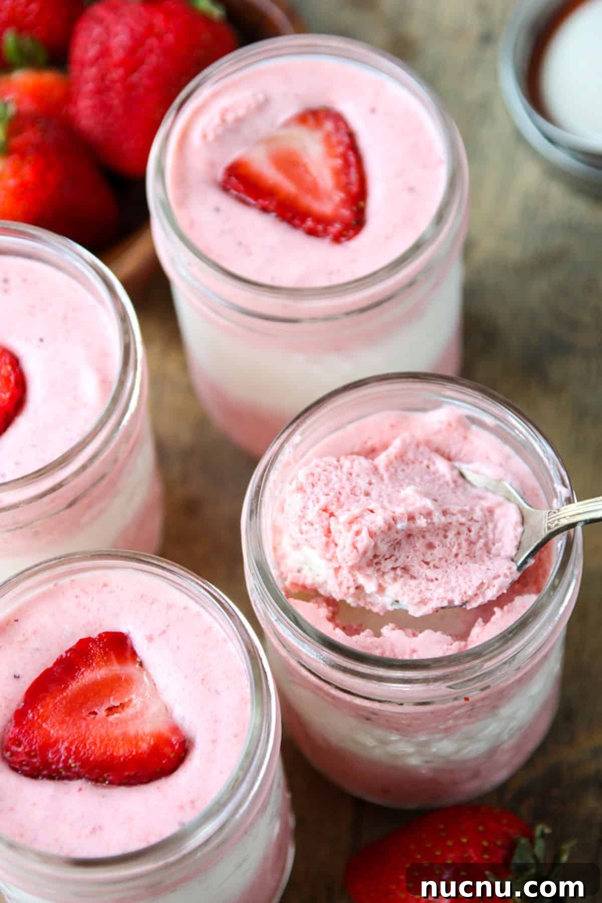 Layered Strawberry Mousse Recipe: Light & Creamy Dessert 6 A spoonful of layered strawberry mousse being scooped from a jar.