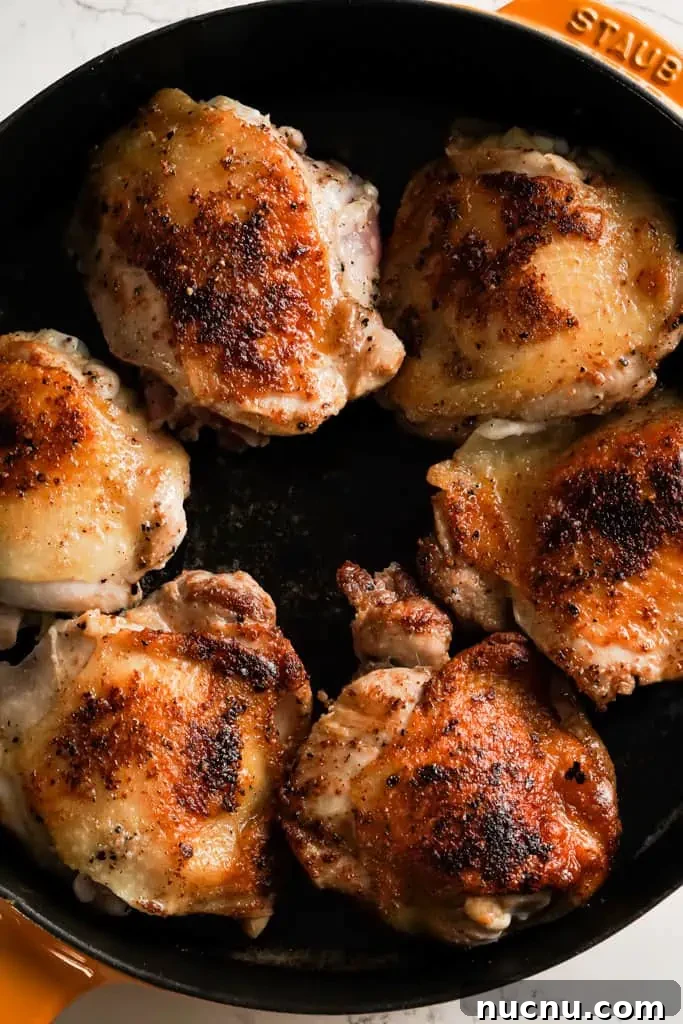 chicken thighs browning in a skillet