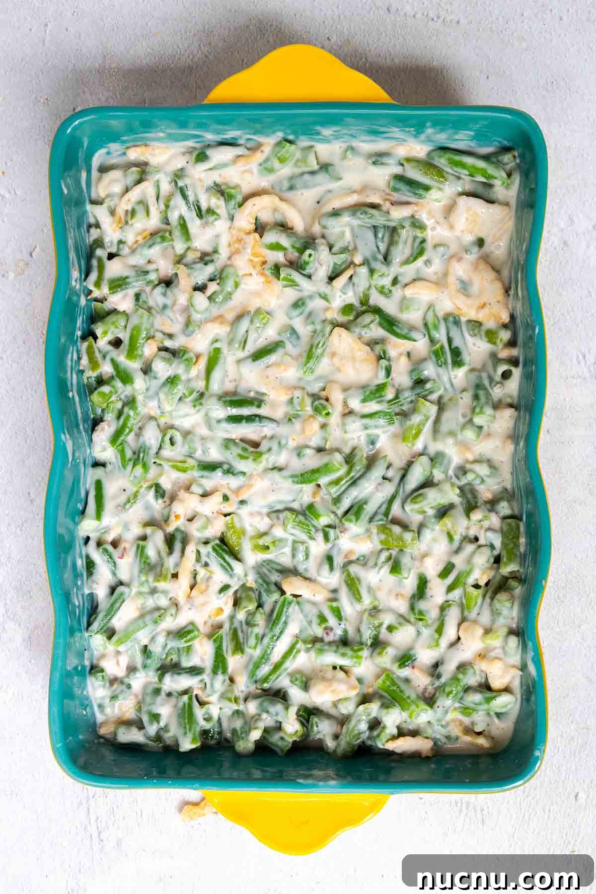 Double Green Bean Casserole Recipe for Family-Sized Meals 4 The green bean casserole filling is spread evenly into the bottom of a 9 by 13 inch casserole dish.
