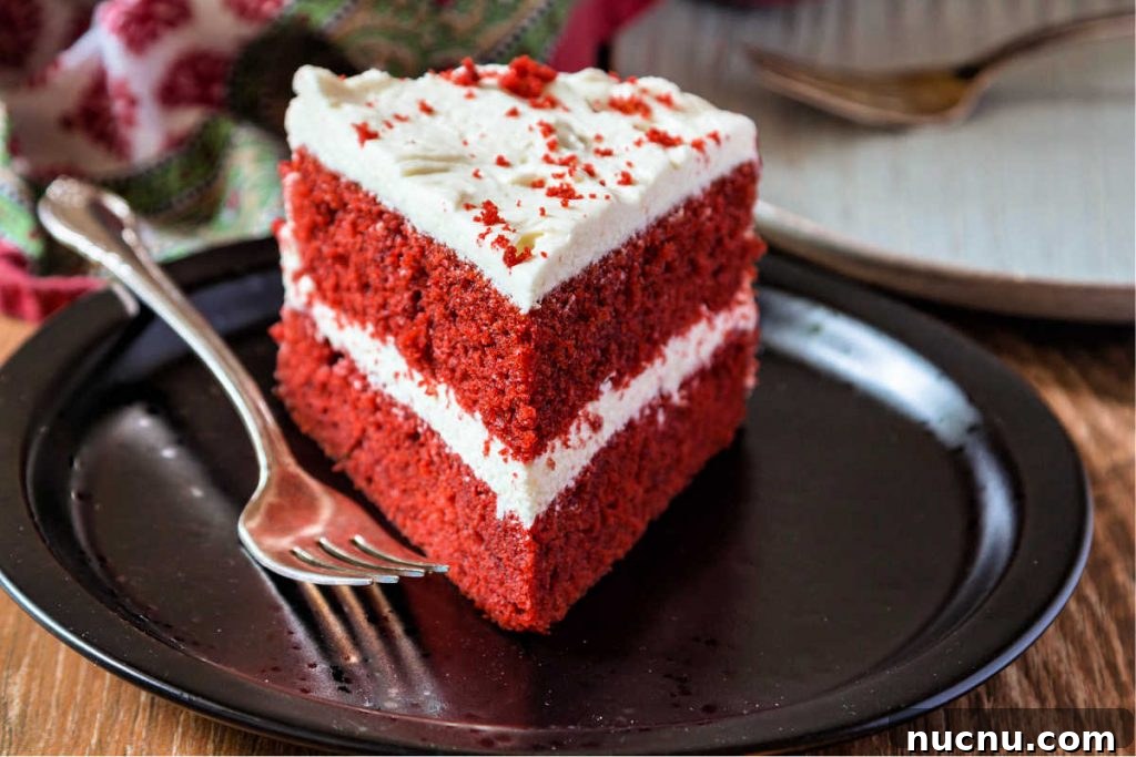 Red Velvet Cake with Silky Ermine Buttercream Frosting 6 slice of red cake with white frosting on a black plate