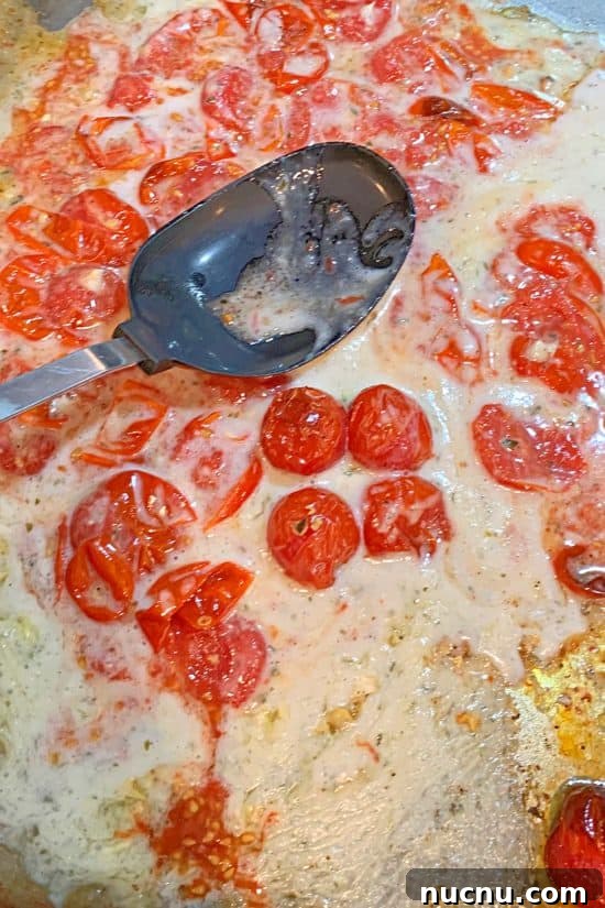 Blistered tomatoes being squashed with the Boursin cheese for a delicious sauce.