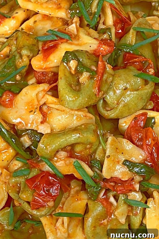 Boursin cheese and olive oil coating tender cheese-filled pasta with cherry tomatoes and baby spinach.