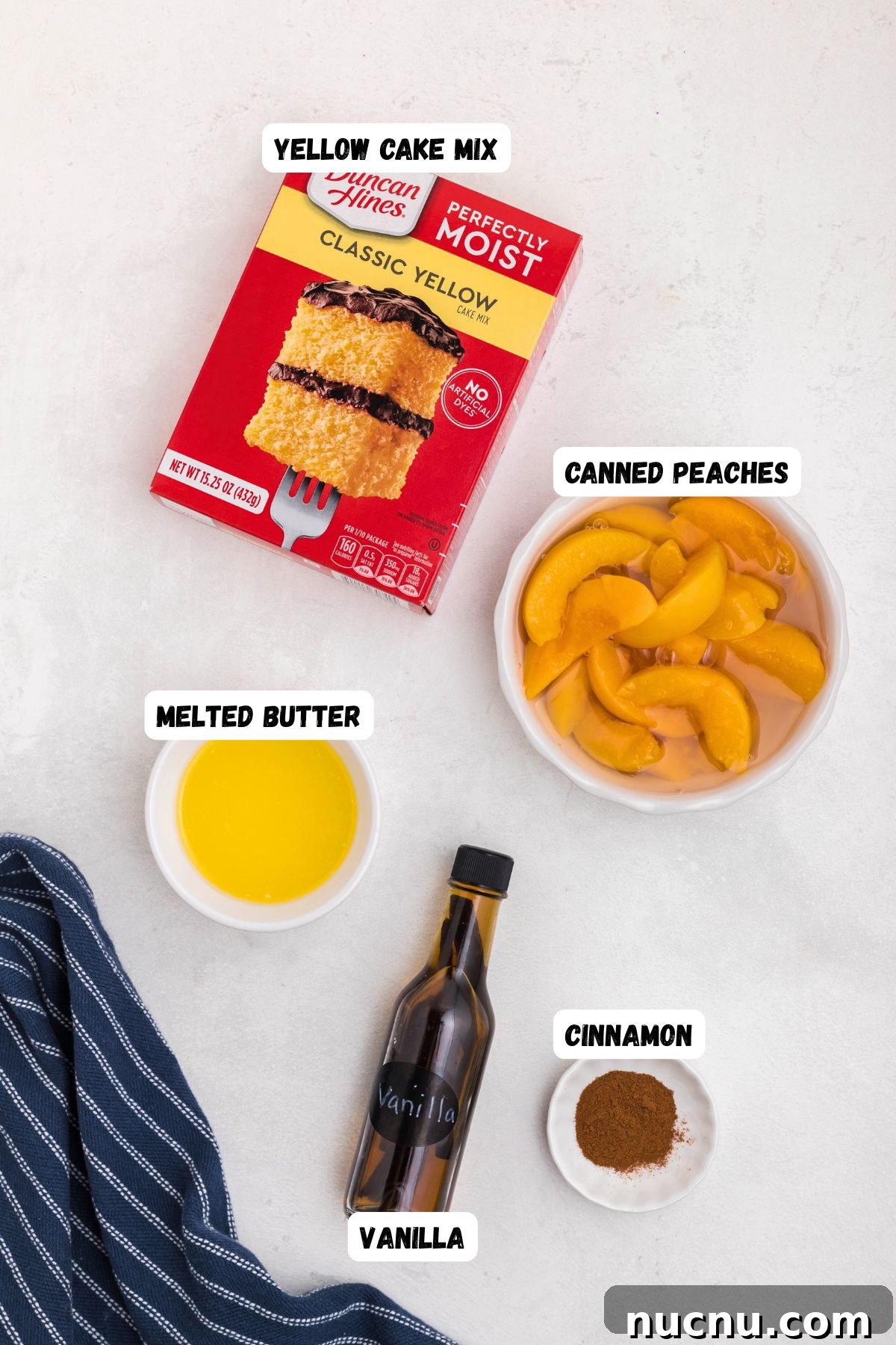 Irresistible Peach Dump Cake Recipe for Quick Summer Desserts 3 Boxed cake mix, peaches, butter, vanilla, and cinnamon, in small bowls on a white marble table.