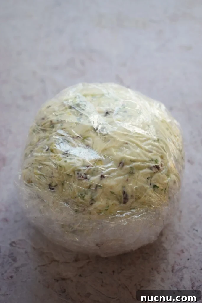 Cranberry Pistachio Goat Cheese Ball Recipe for Parties 11 Cheese ball in plastic wrap.