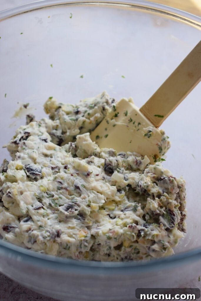 Cranberry Pistachio Goat Cheese Ball Recipe for Parties 9 Mixed goat cheese with nuts and cranberries in a bowl.