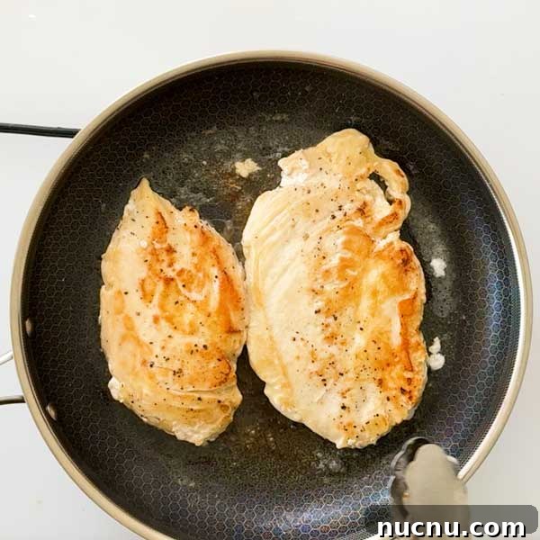 Gluten-Free Sweet and Sour Chicken Made in a HexClad Pan 7 Two chicken breasts in a frying pan.