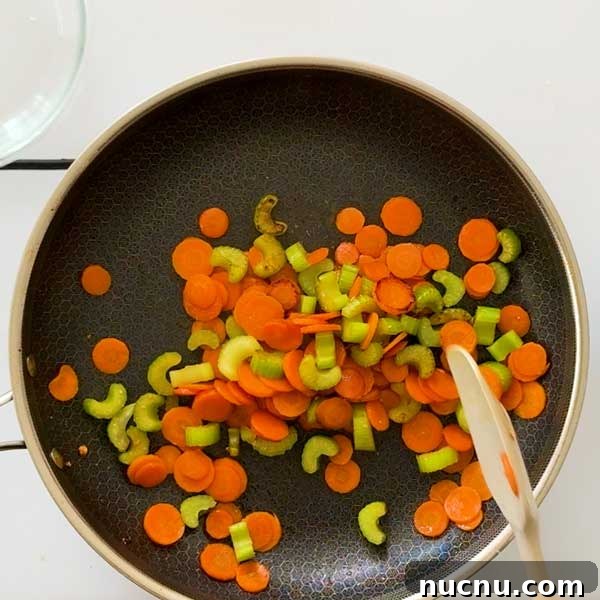 Gluten-Free Sweet and Sour Chicken Made in a HexClad Pan 8 Stirring carrots and celery in a frying pan.