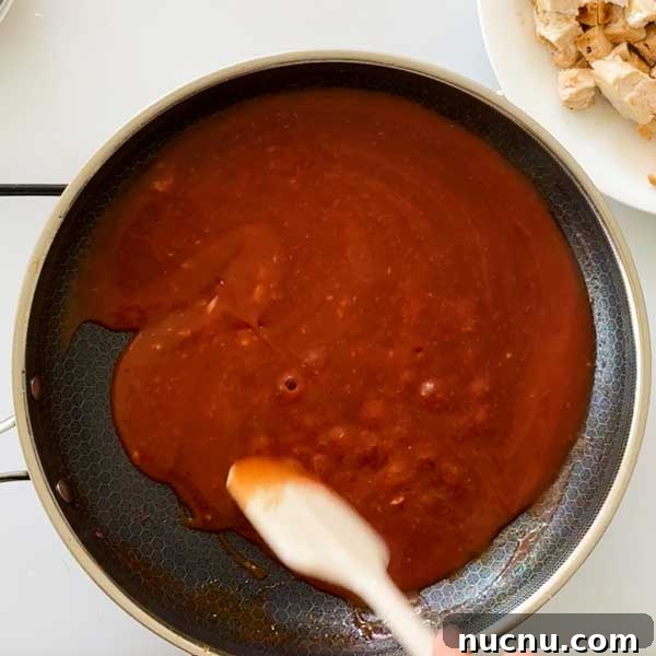 Gluten-Free Sweet and Sour Chicken Made in a HexClad Pan 9 Stirring sweet and sour sauce in a frying pan.