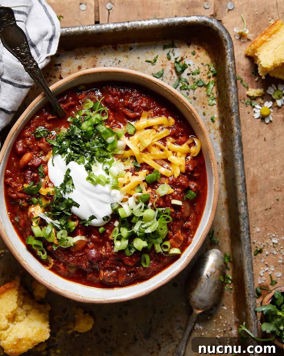 A bowl of dutch oven chili with cheese and sour cream.