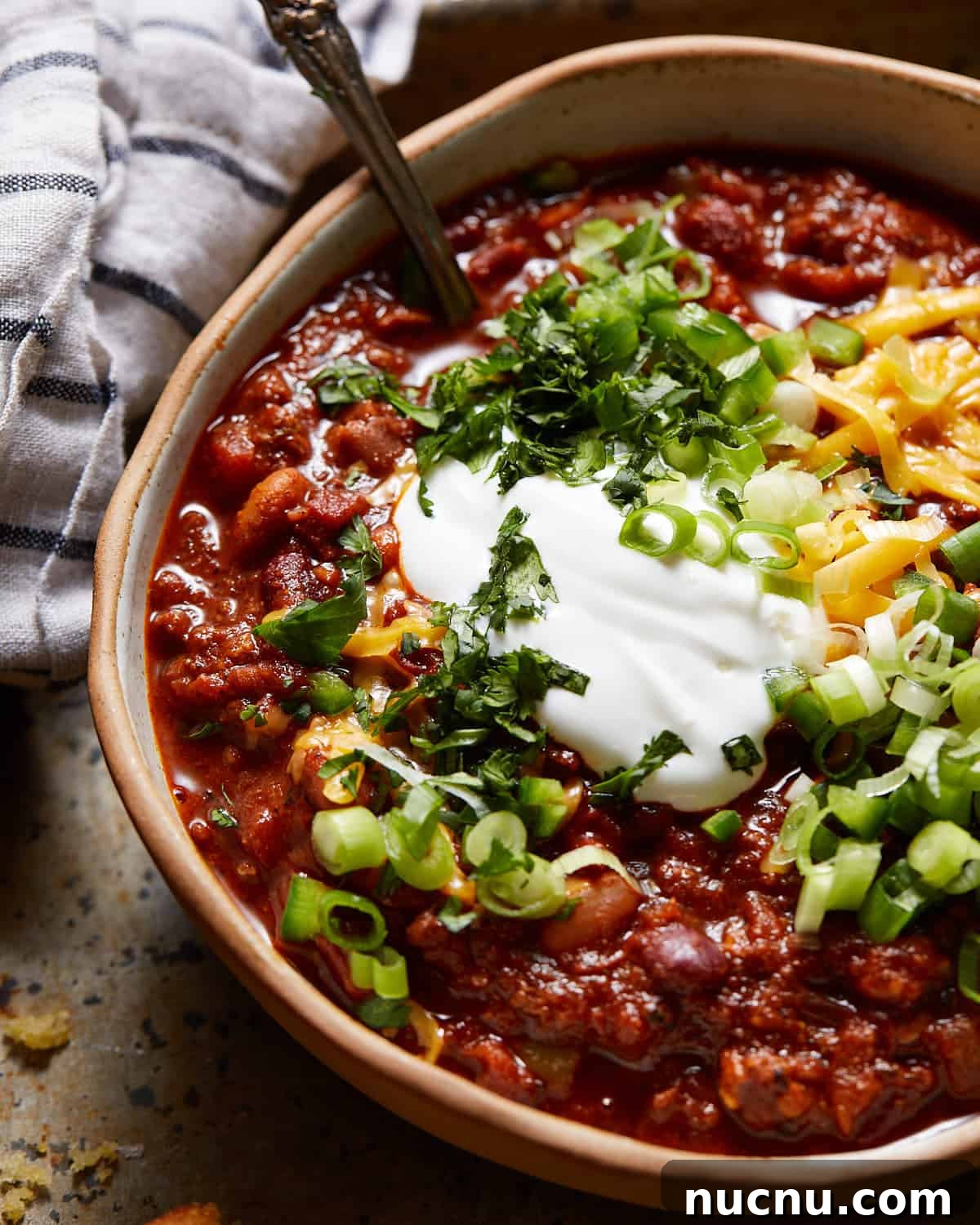 Dutch oven chili in a bowl with toppings.