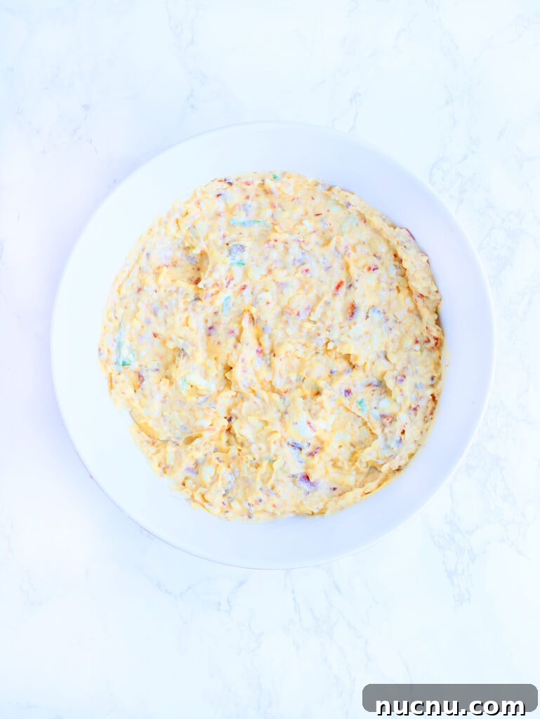 Spicy Chipotle Pimento Cheese Spread Recipe 5 Mixed pimento cheese ingredients in a white mixing bowl.