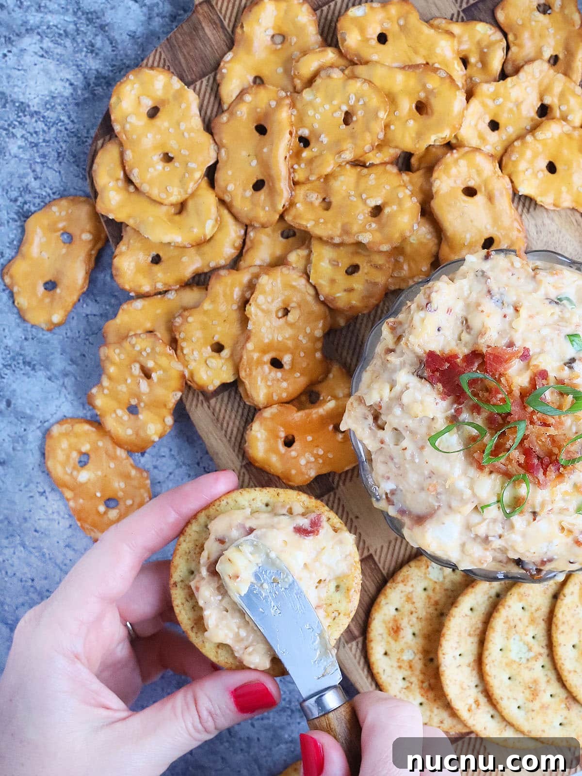 Spicy Chipotle Pimento Cheese Spread Recipe 6 Pair of hands spreading spicy pimento cheese onto a cracker.