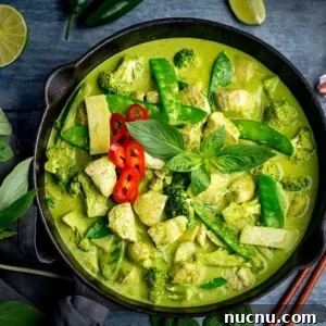 Authentic Thai Green Chicken Curry Recipe (Step-by-Step) 8 Square image of Pan of Thai green chicken curry with vegetables on blue background