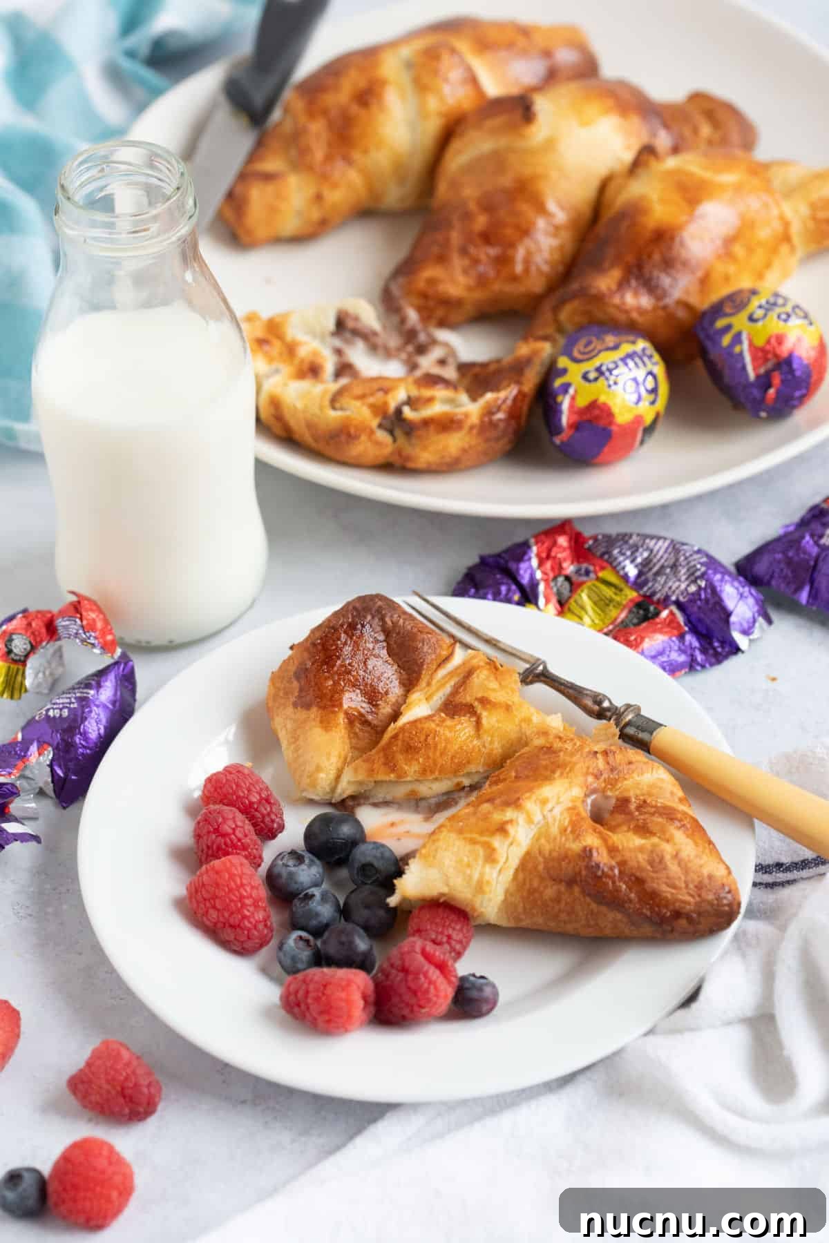 Air Fryer Creme Egg Croissant Recipe: Crispy Chocolate & Custard Croissant 2 Air fryer creme egg croissant on a white plate with berries.