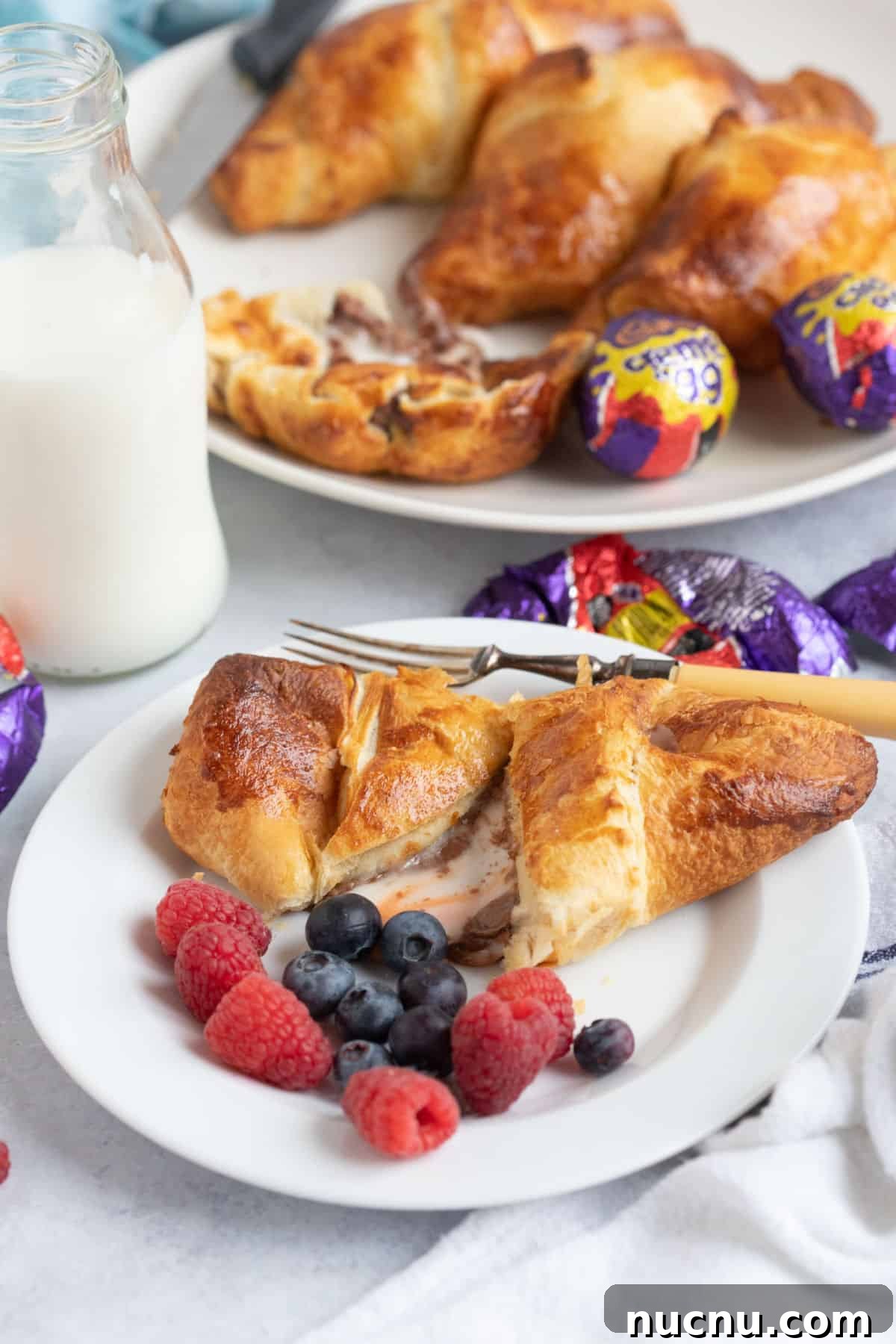 Air Fryer Creme Egg Croissant Recipe: Crispy Chocolate & Custard Croissant 7 A creme egg croissant pulled in half with the melted chocolate and fondant oozing out onto the white plate.