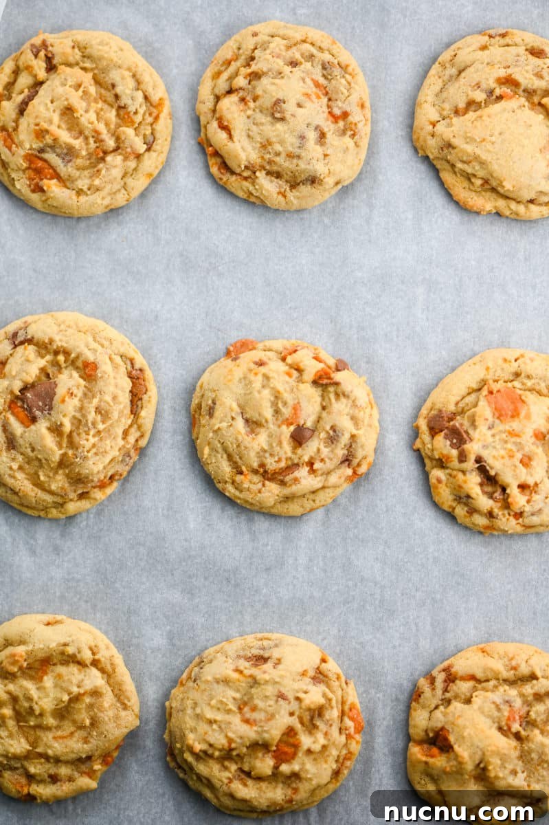 25 Unique Cookie Recipes You’ll Want to Bake Now 8 butterfinger cookies on a sheet pan.