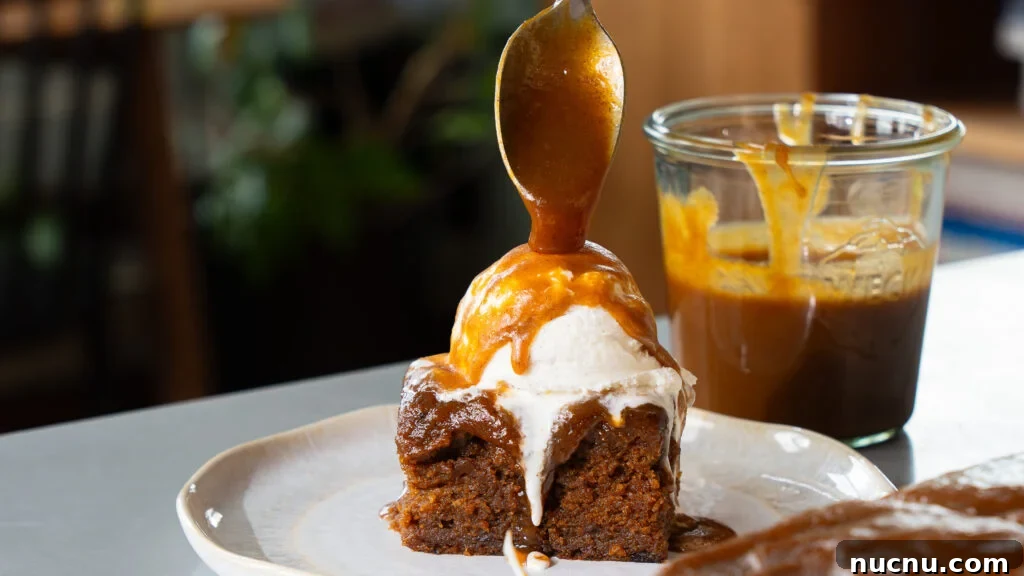 Pumpkin Sticky Toffee Pudding with Butterscotch Sauce Recipe 4 Pumpkin sticky toffee pudding cake on a plate with a scoop of vanilla ice cream on top and pumpkin butterscotch sauce.