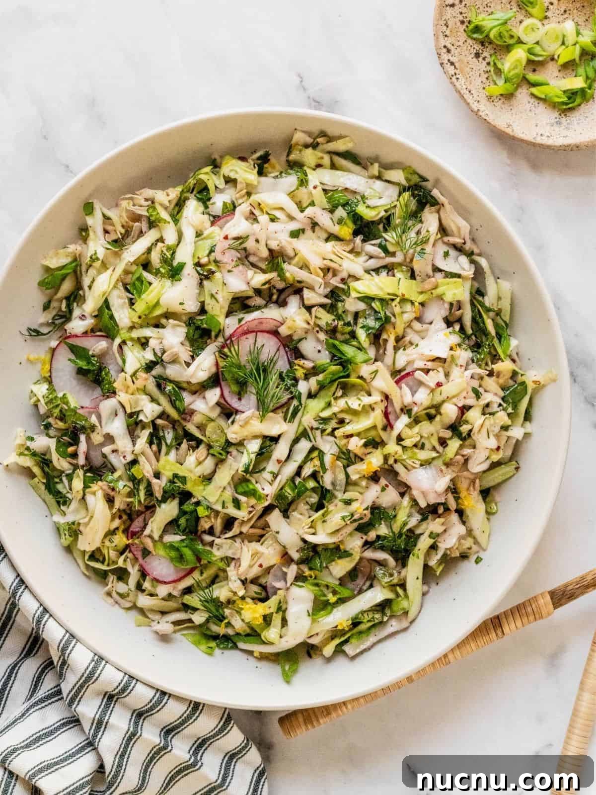 Lemon Sumac Coleslaw (No Mayo) — Tangy, Fresh Side Dish 9 No mayo coleslaw with radish, fresh herbs in a lemon sumac dressing in a bowl.