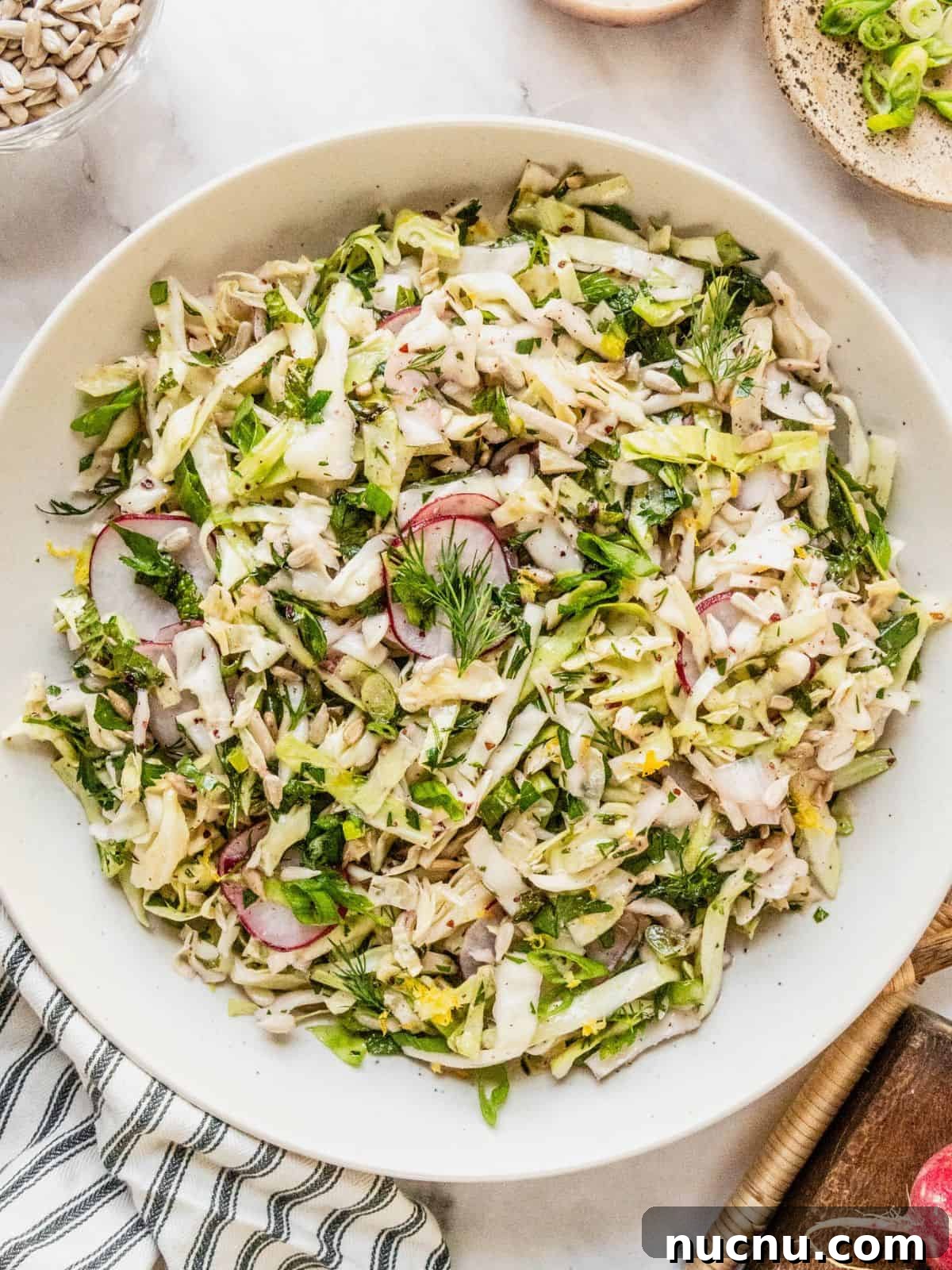 Lemon Sumac Coleslaw (No Mayo) — Tangy, Fresh Side Dish 10 No mayo coleslaw with radish, fresh herbs in a lemon sumac dressing in a bowl.