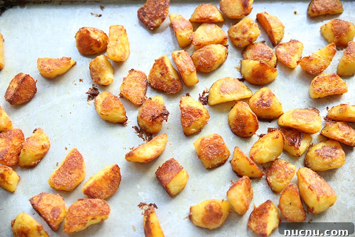 A baking sheet full of extra crispy roasted potato chunks.