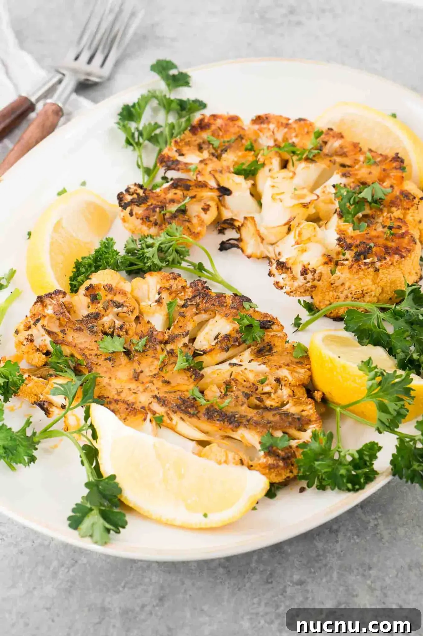 Roasted Cauliflower Steaks with Garlic and Herb Butter 6 seasoned roasted cauliflower steaks on a plate