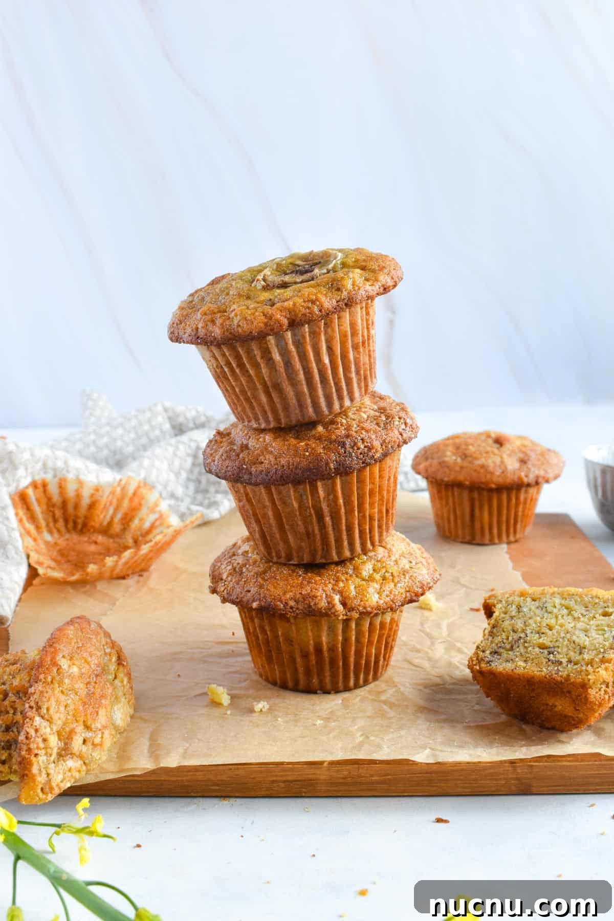 Moist Banana Bread Without Baking Soda: Simple Oven Recipe 11 stack of 3 banana muffins on wooden board.